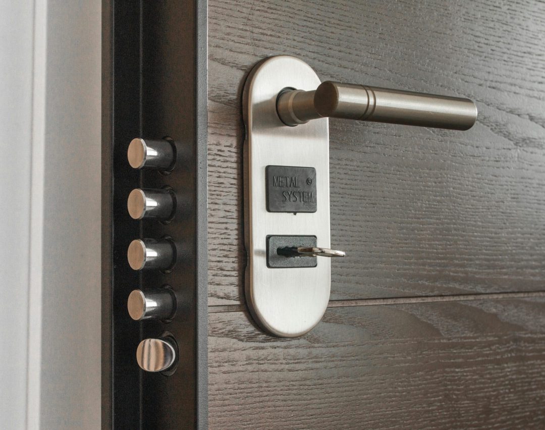 Metal door handle and lock system with key inserted, showcasing security features.